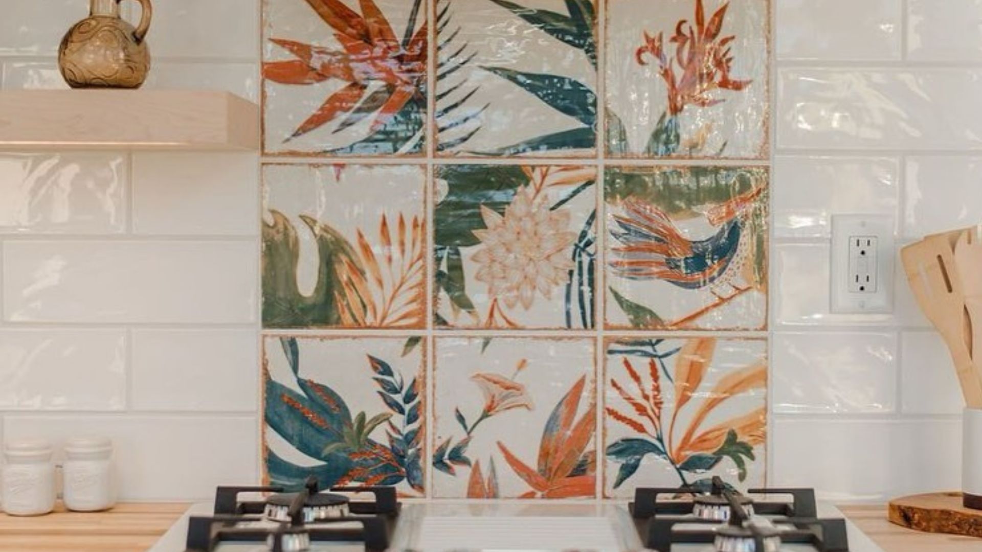 exotic floral backsplash in the kitchen behind a four-burner stovetop