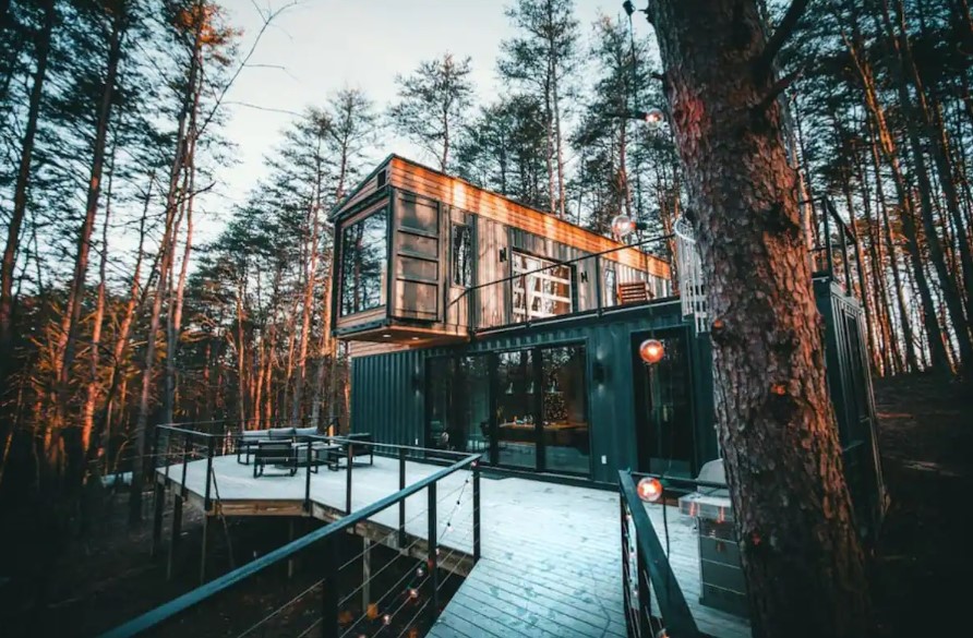 container house in the woods with black exterior