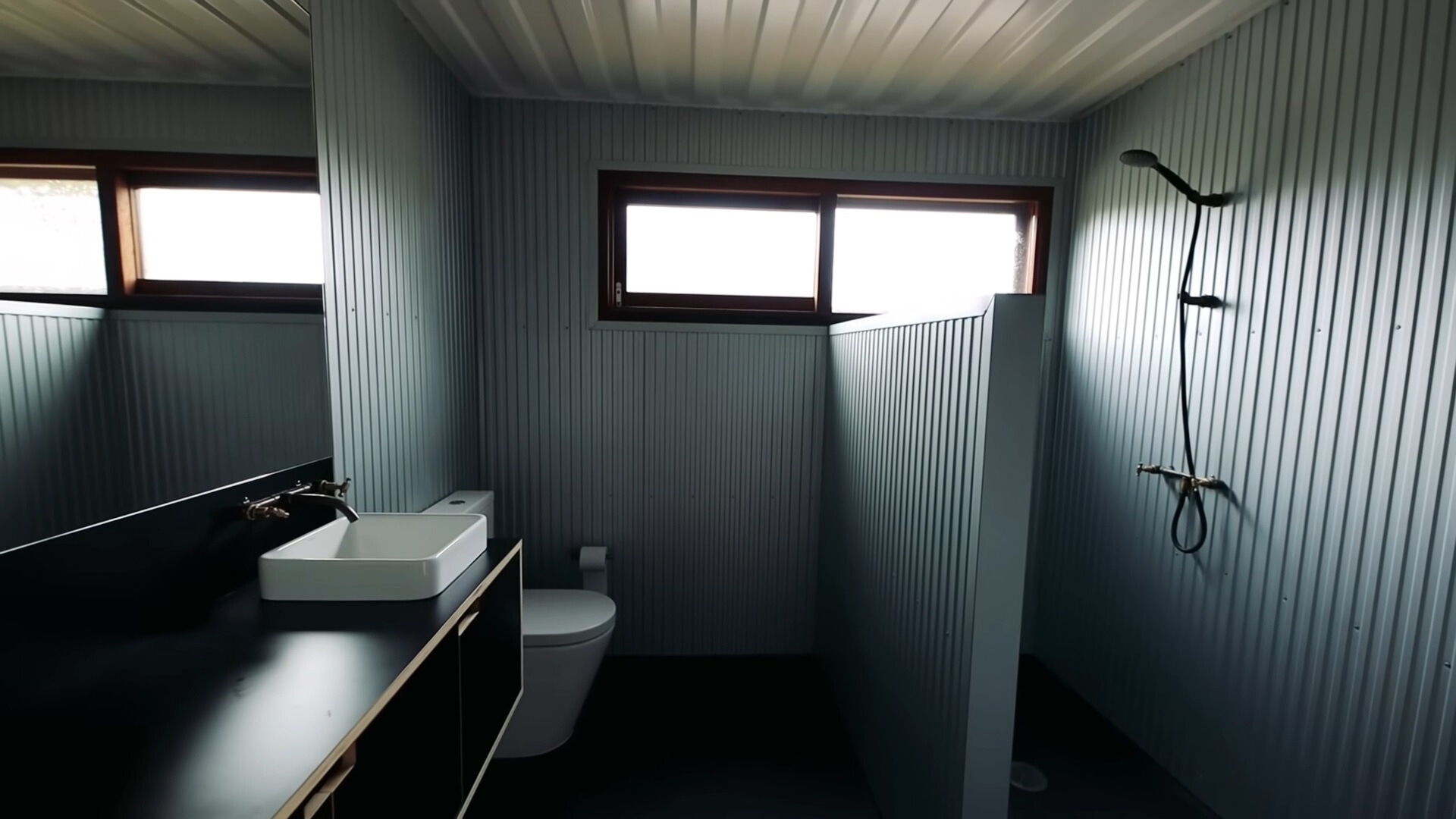 minimalist bathroom with a white sink and a black cabinet