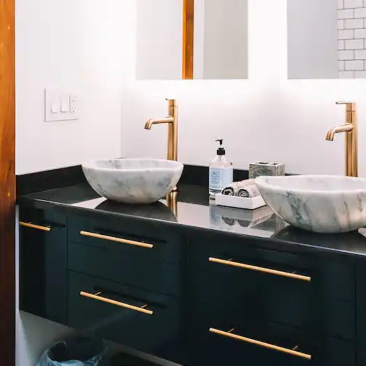 double vanity in midniht blue with marble sinks and gold faucets and light up mirrors