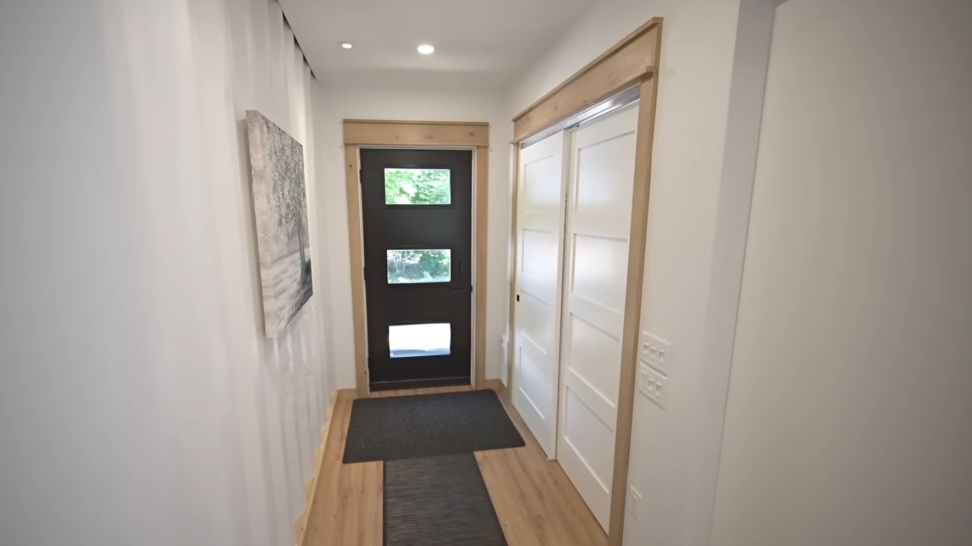 entry into the container home with a corrugated wall on the left and storage cloets on the right