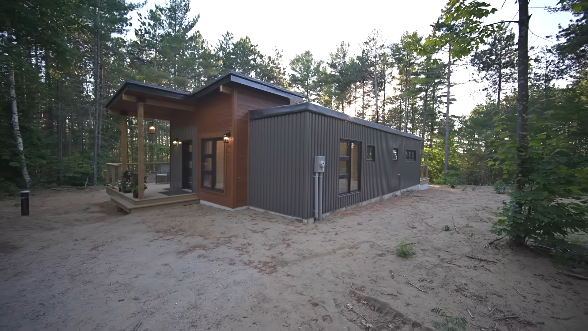 grey and brown exterior of the container home in the woods