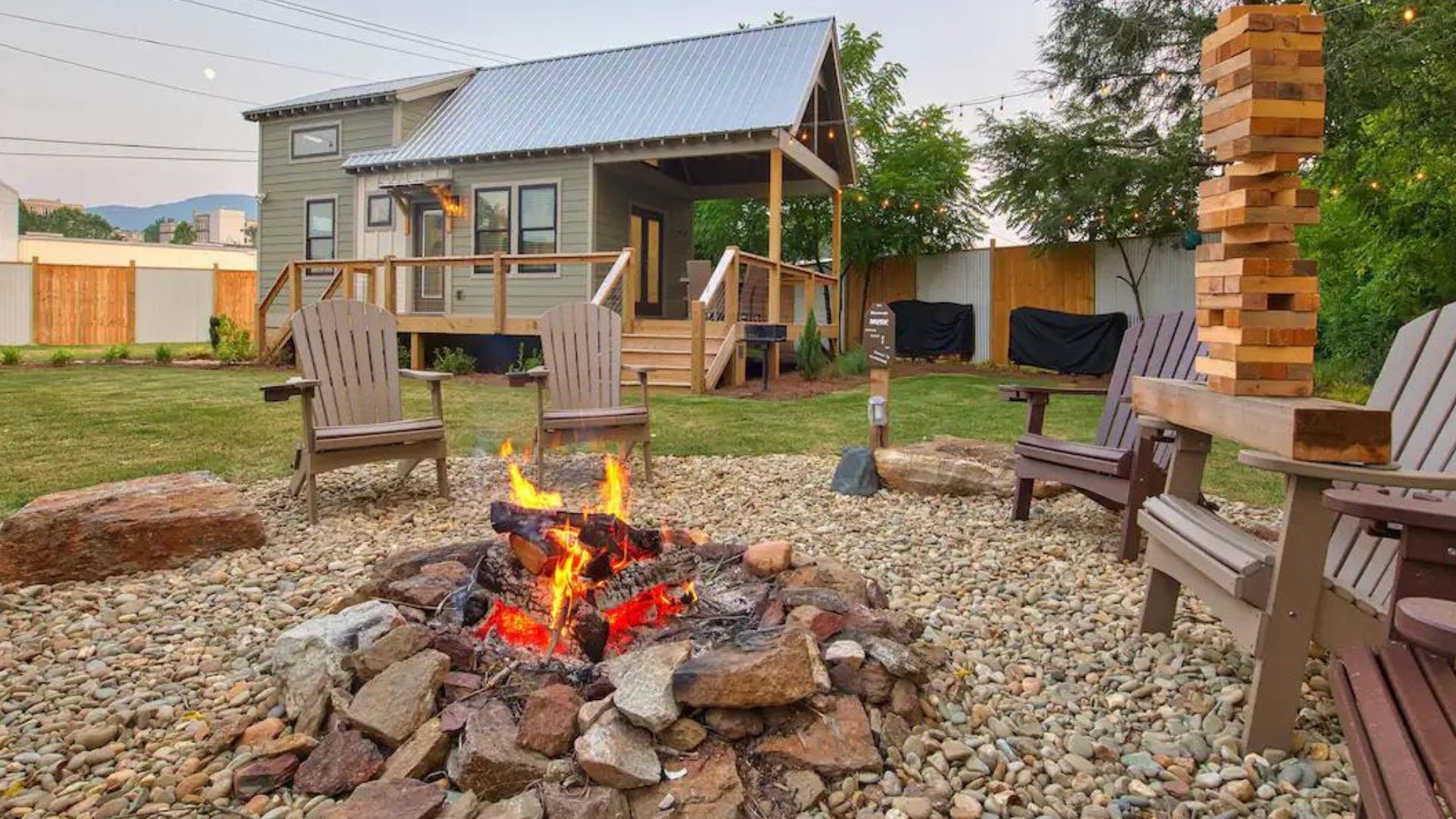 fire pit area in the garden, fire burning, wooden chairs around the pit