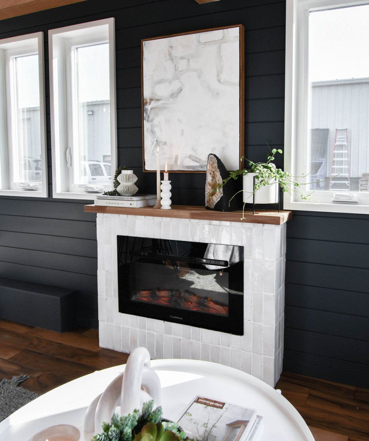 fireplace surrounded by white tiles in a house with dark walls