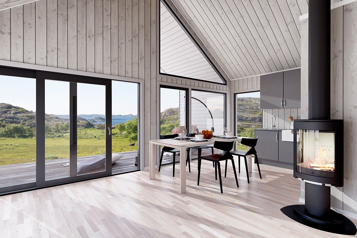 cabin with floor to ceiling windows and glass doors that looks out on the green land and the sea