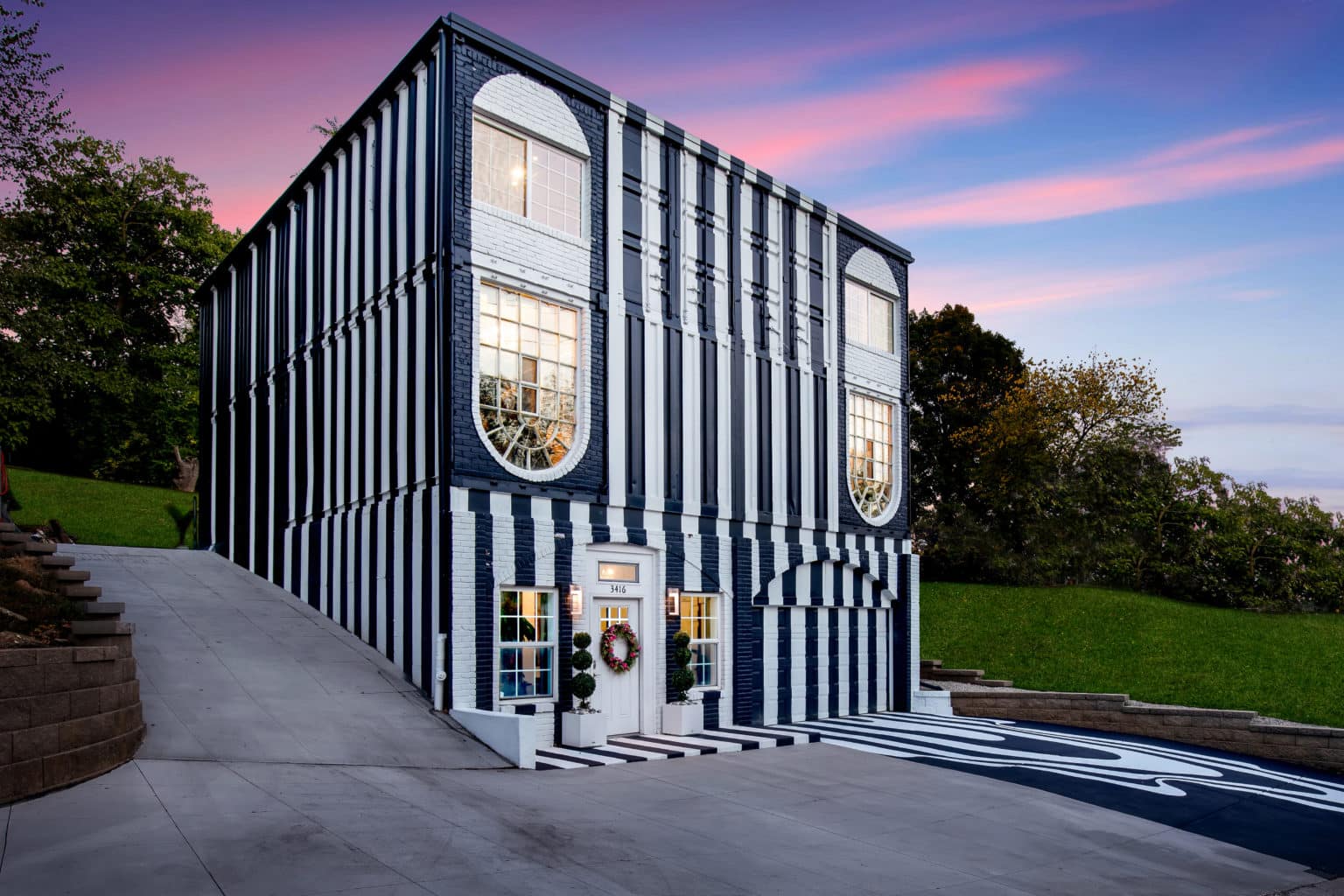 container house with a black and white exterior and pink and blue sky