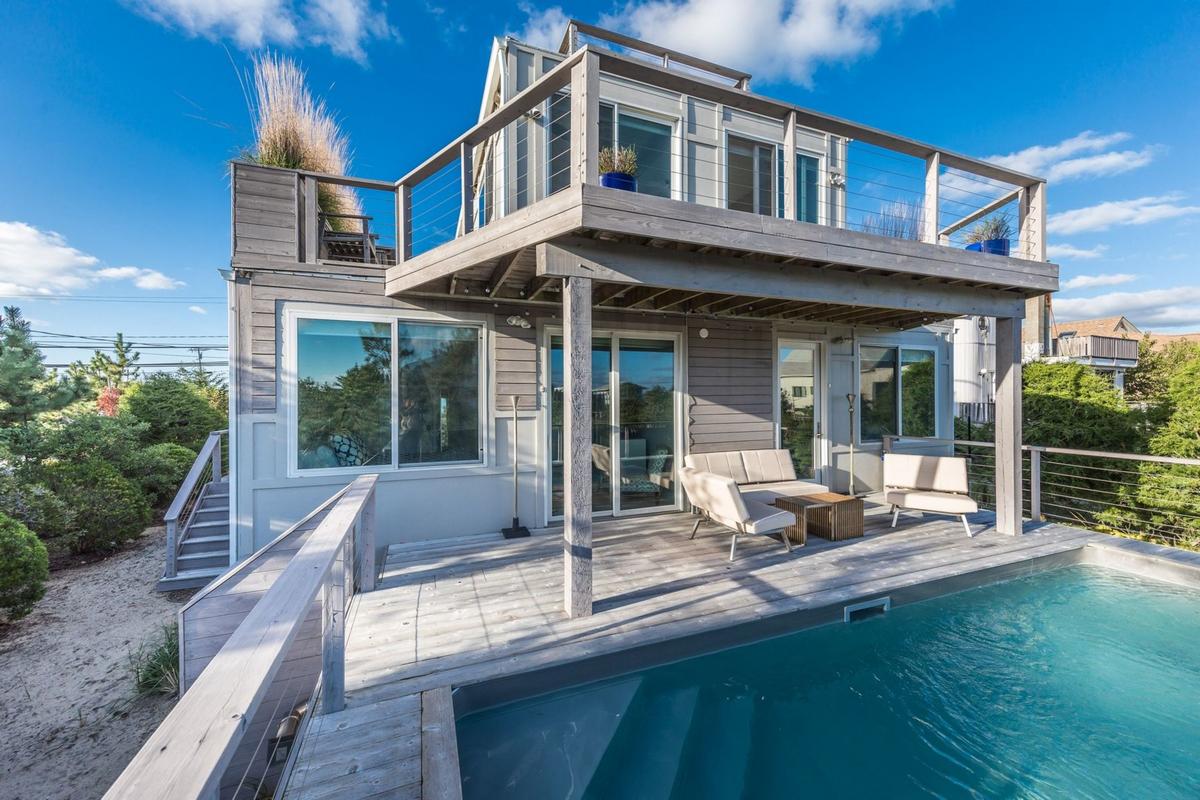 house with a white and gray exterior and a pool