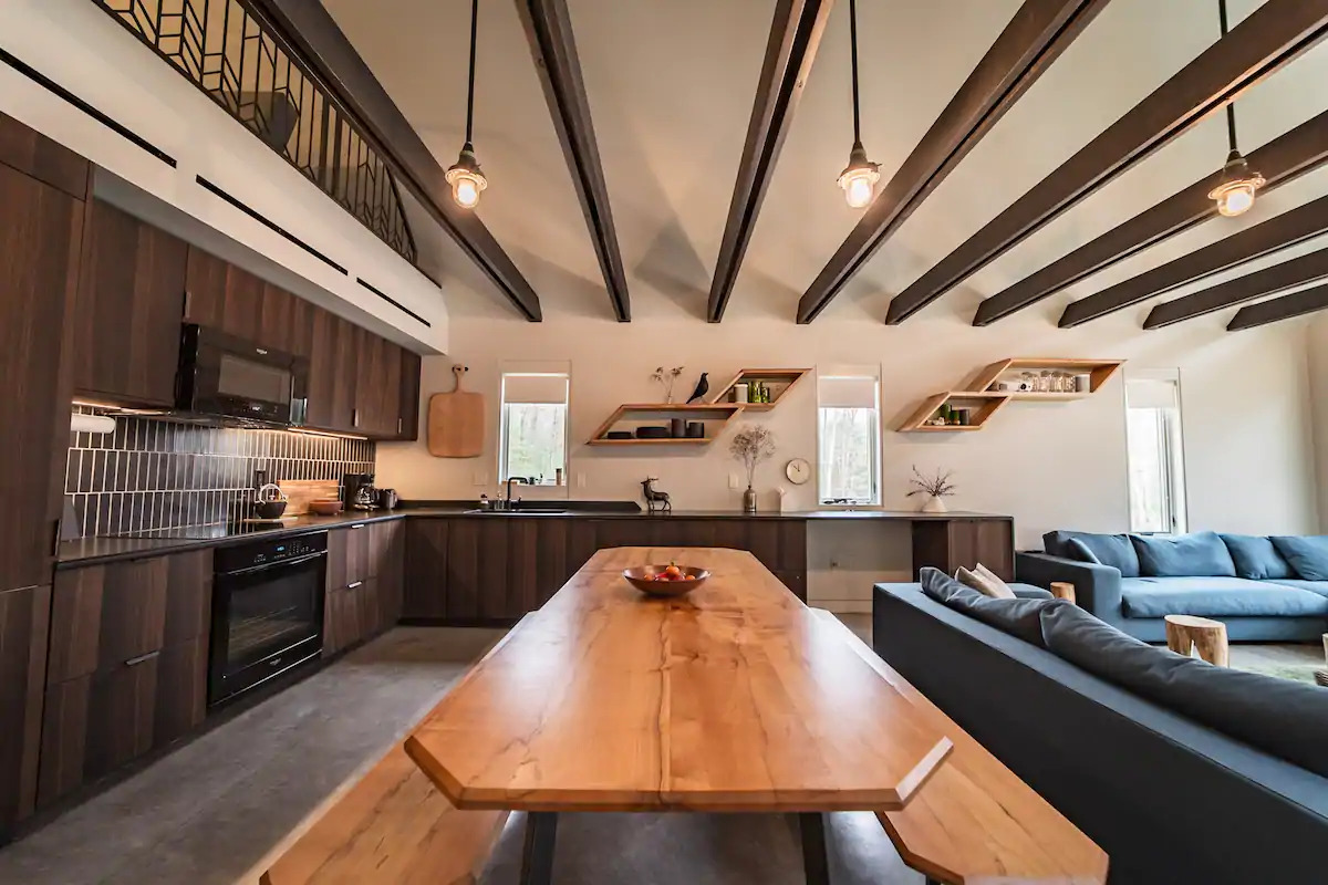 kitchen and dining room areas with brown cabinets and a long, brown dining table and benches