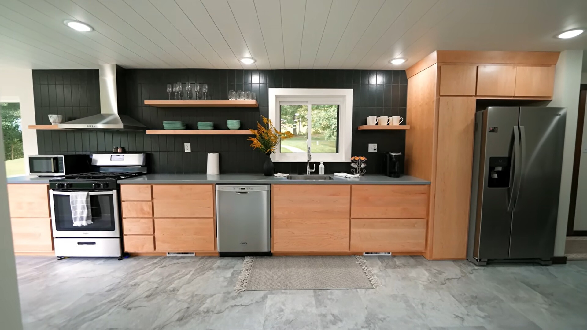 kitchen with a dark gray countertop, brown cabinets and black tiles