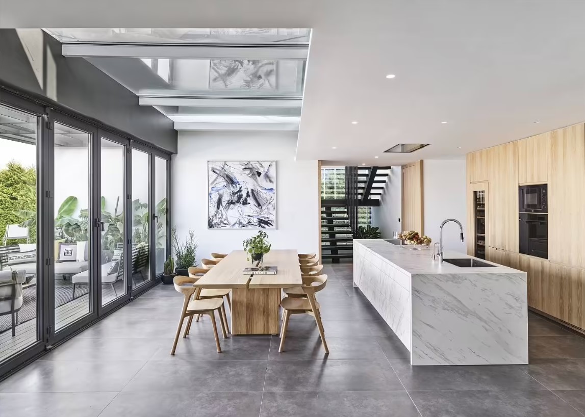 kitchen with a white marble countertop, brown cabinets and a brown dining table and chairs