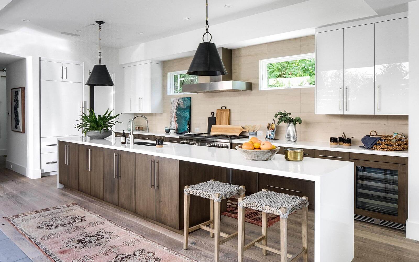 kitchen with white and brown cabinets with white countertops and two bar stools