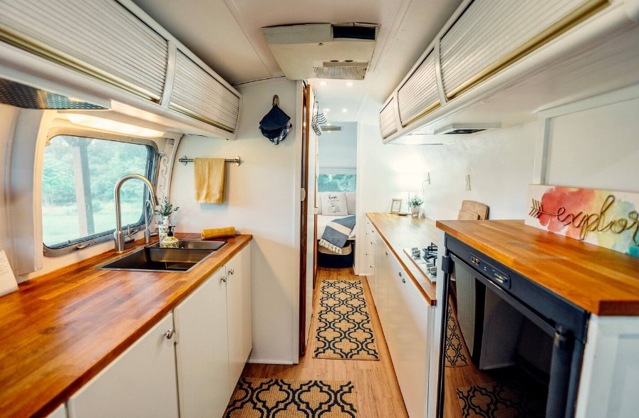 kitchen with brown countertops on both sides and white cabinets