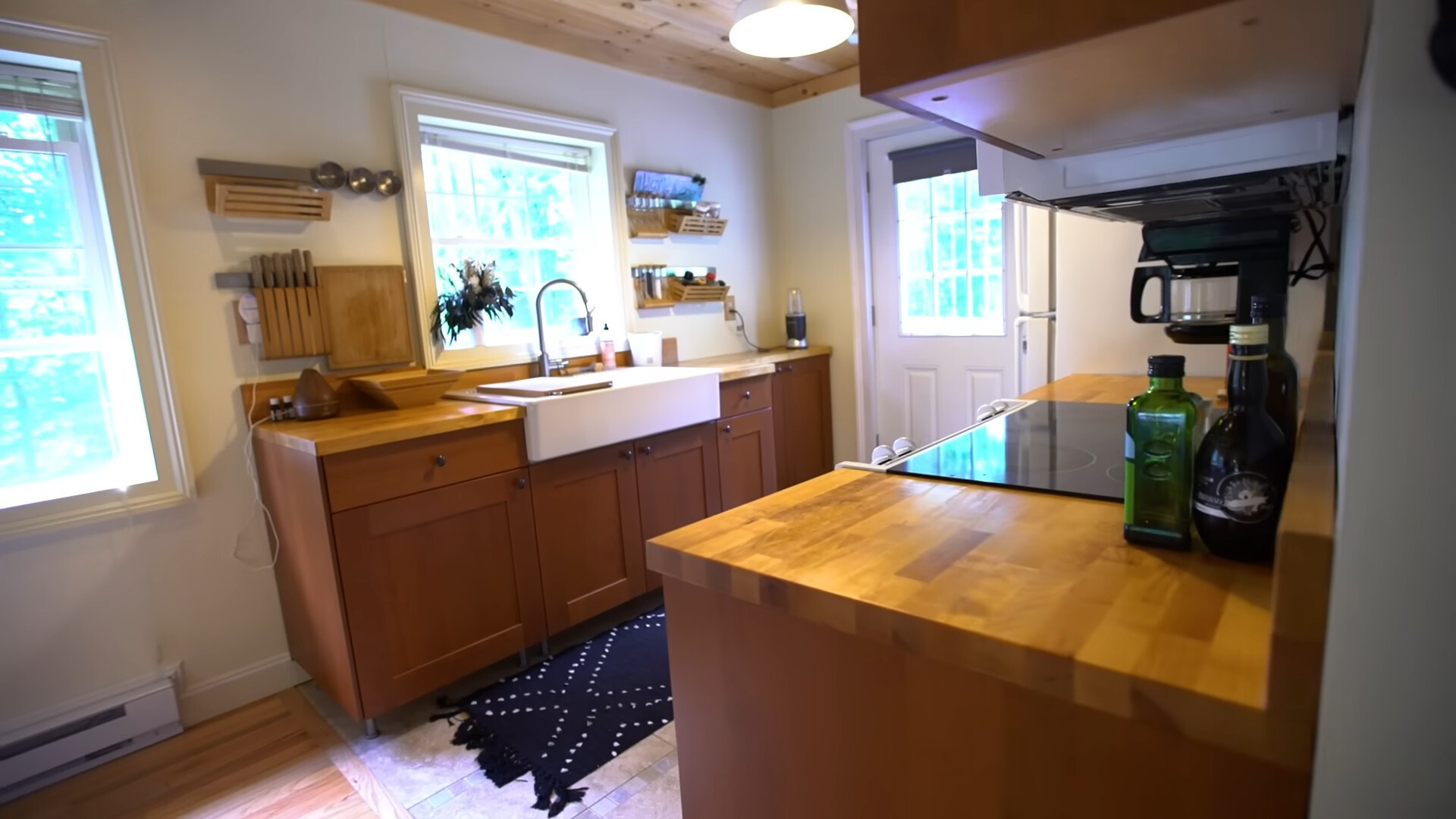 kitchen with two brown countertops and brown cabinets and big, white sink with a window above