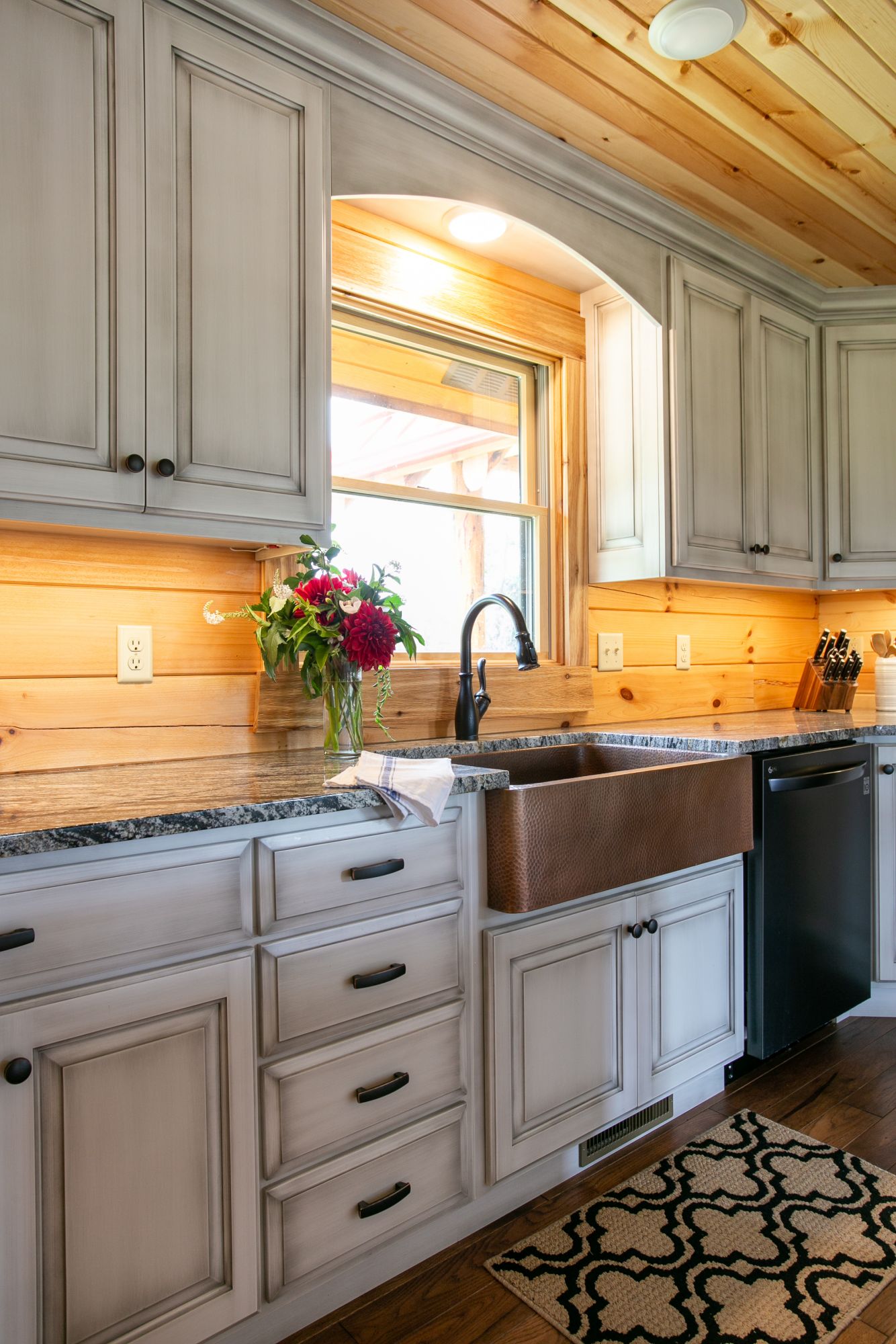 kitchen with white cabinets and a window and a copper sink