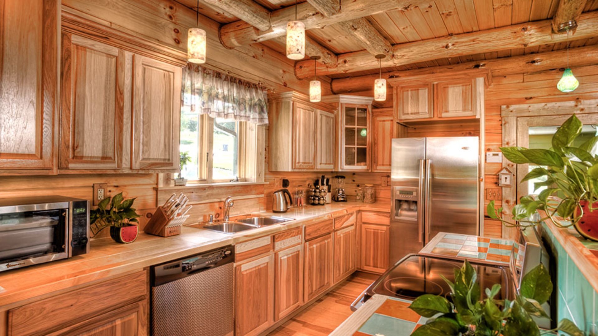 big and spacious kitchen with wood cabinets, stainless steel appliances, and a kitchen island covered in tiles