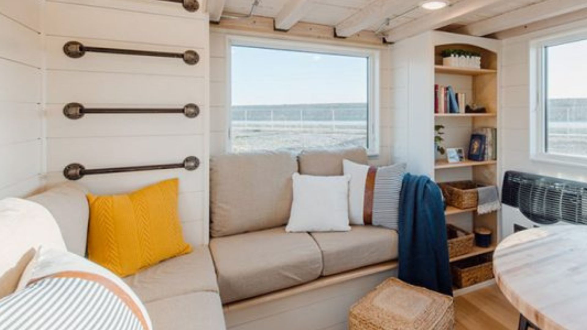 living room area with built-in sofa, cushions, a shelf, and pipe ladder that leads to the second loft