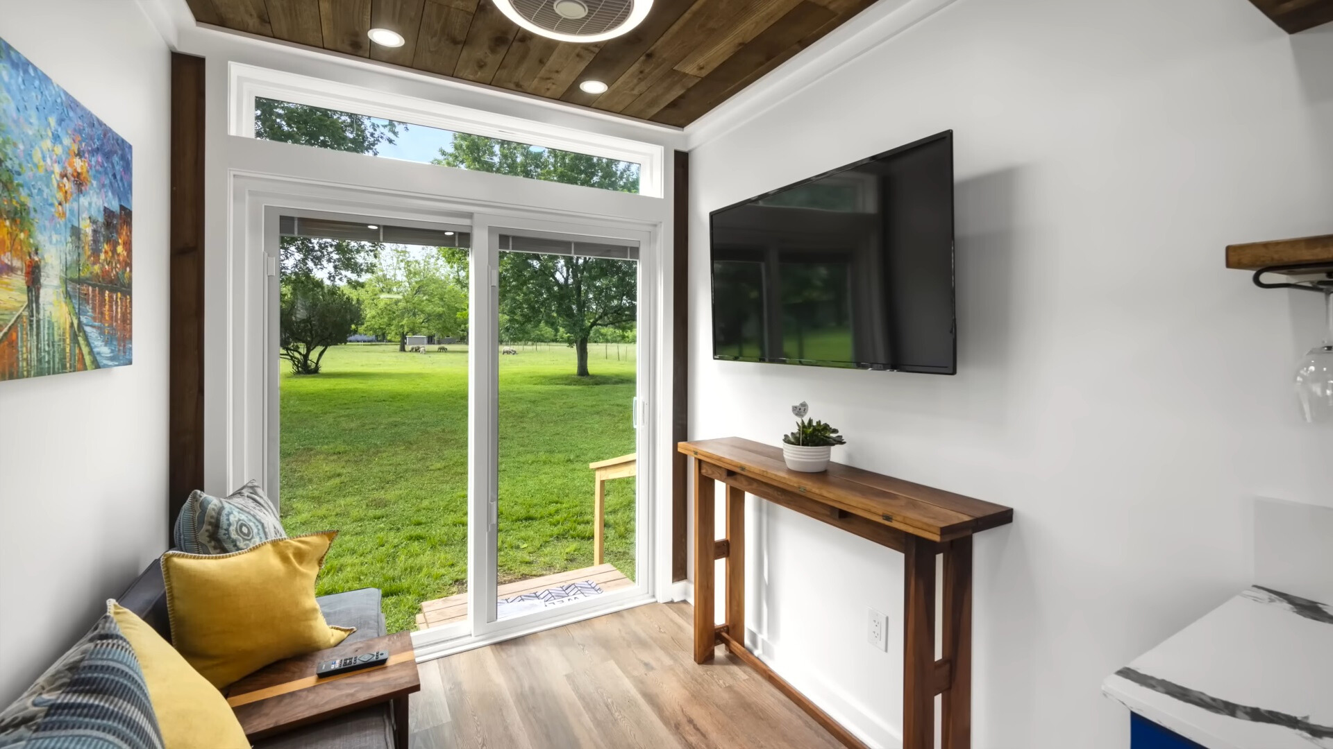 living room with glass doors, tiny brown table, flat screen tv and a couch