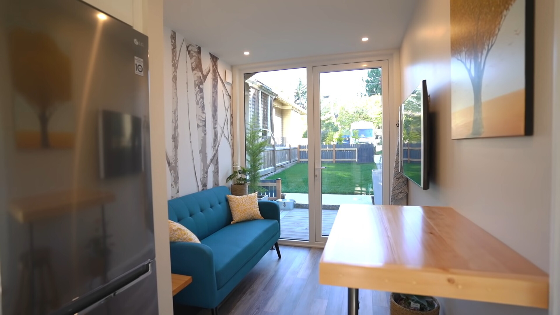 living room with a blue couch, flat screen tv and glass doors