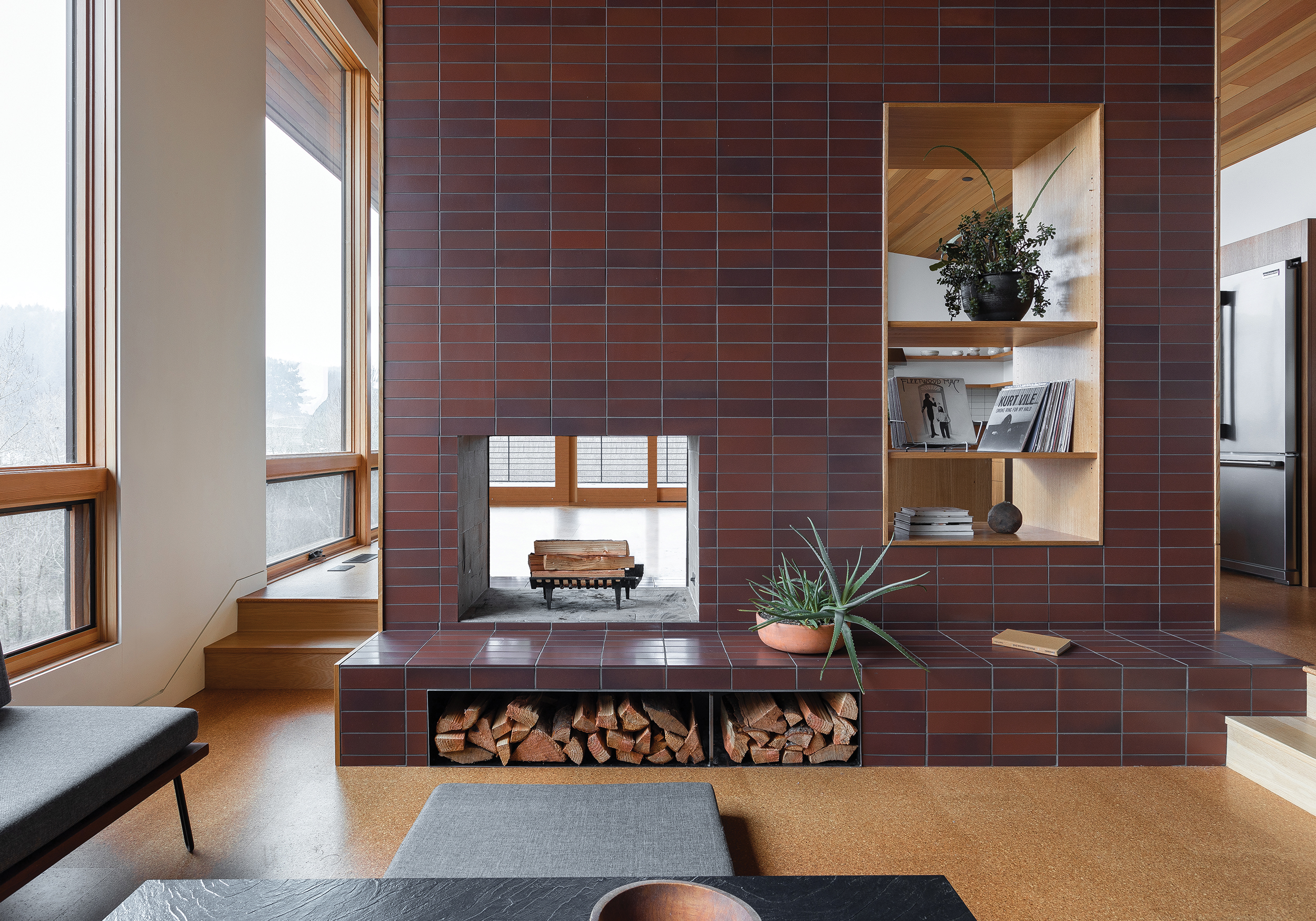 living room with a brick wall, a fireplace and floor to ceiling window