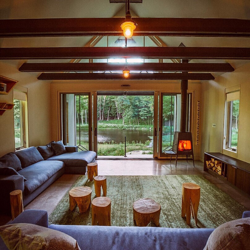 living room with a pond view, blue couches and a fireplace and wooden furniture