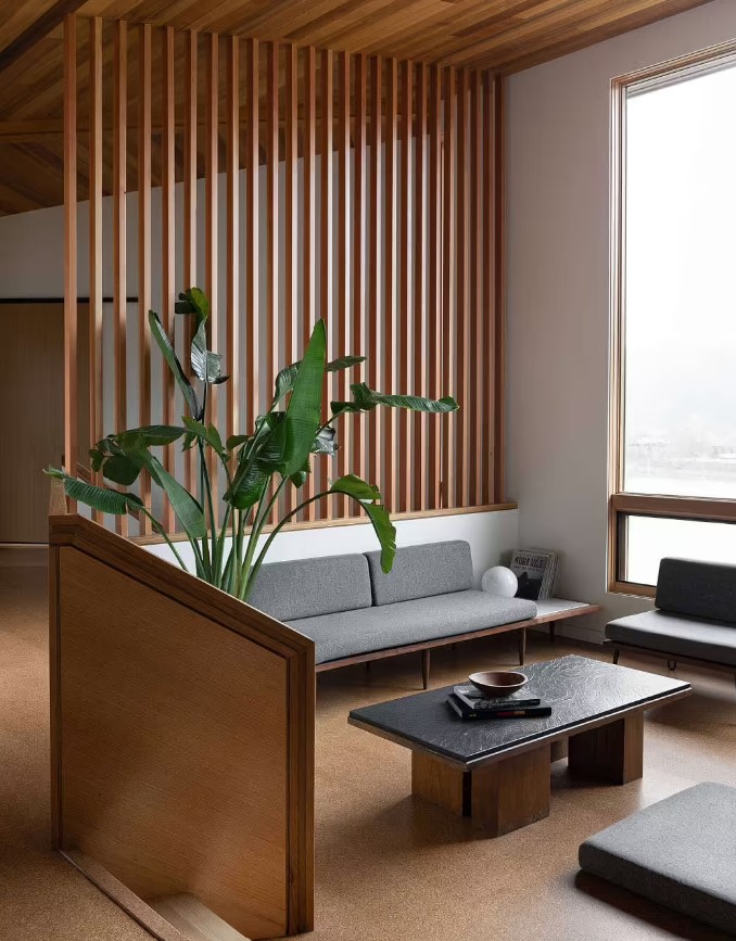 living room with sleek gray couch, a small black table and a big window