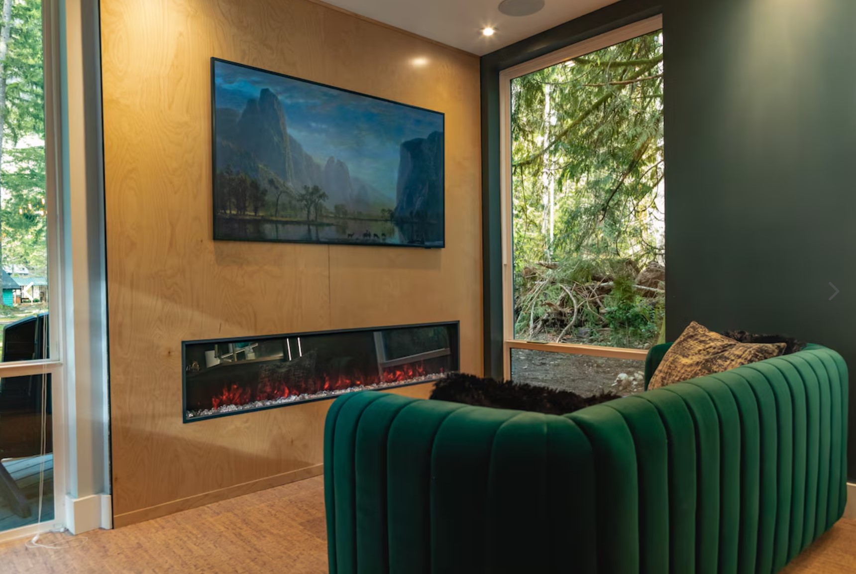 Living room with large windows and a green couch