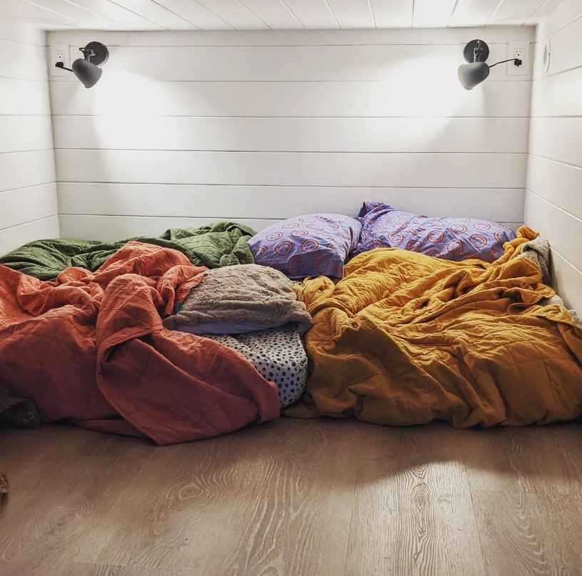 loft with a sleeping area and two lamps in the corners