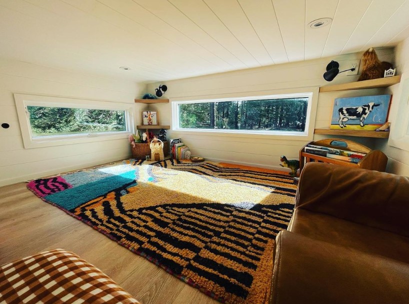 loft with two windows, a colorful carpet and a lot of toys