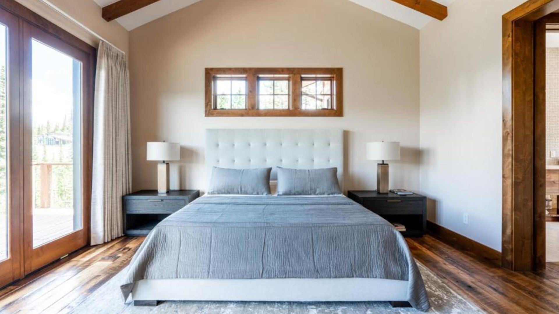 white bed with grey covers in master bedroom and plenty of natural light