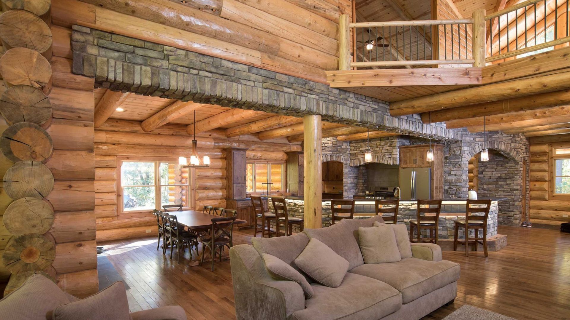 stone veneers in living room with log walls, living room and dining room area, with kitchen in the back