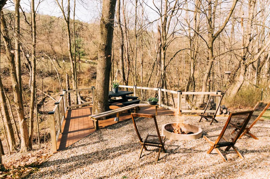 outside area of a container house with a fire pit and a black table with benches