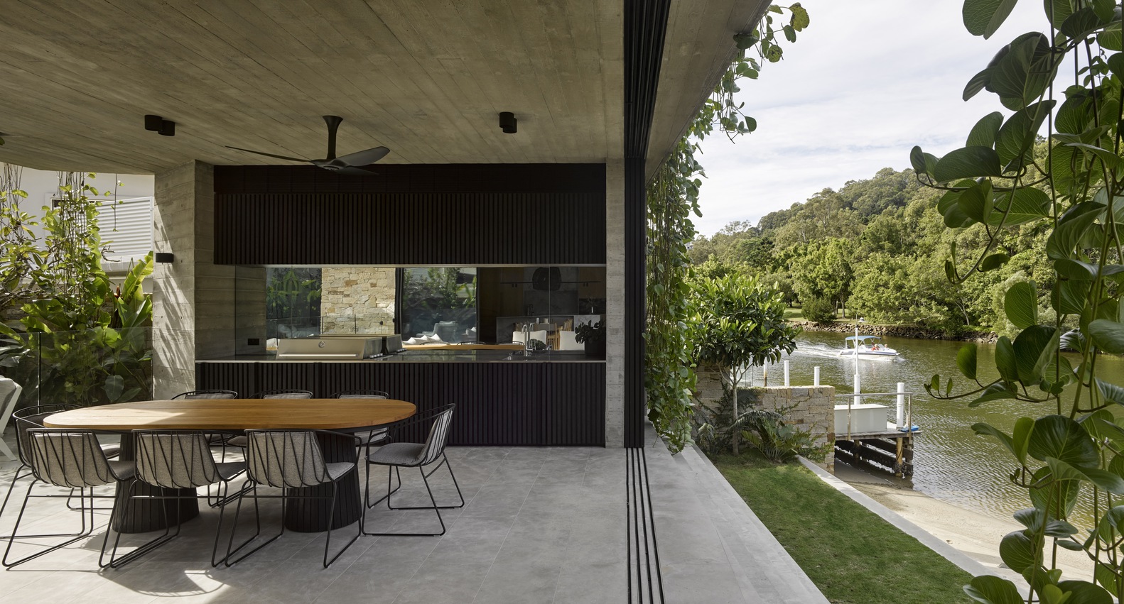 outside kitchen of a modern house with a brown dining table and chairs