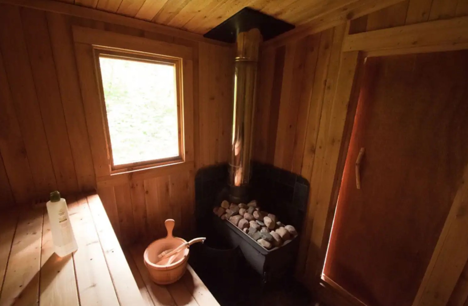 small wooden sauna next to cabin