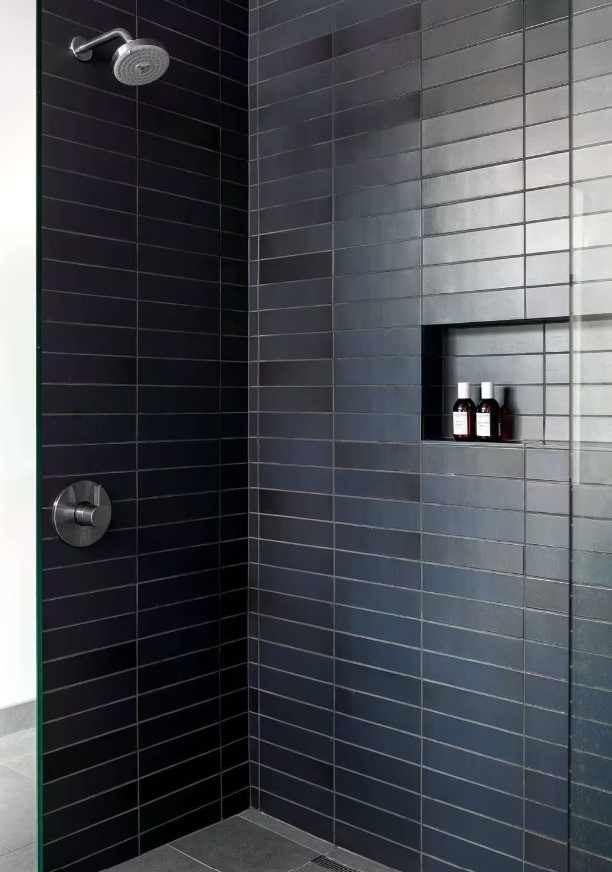 shower with dark blue tiles