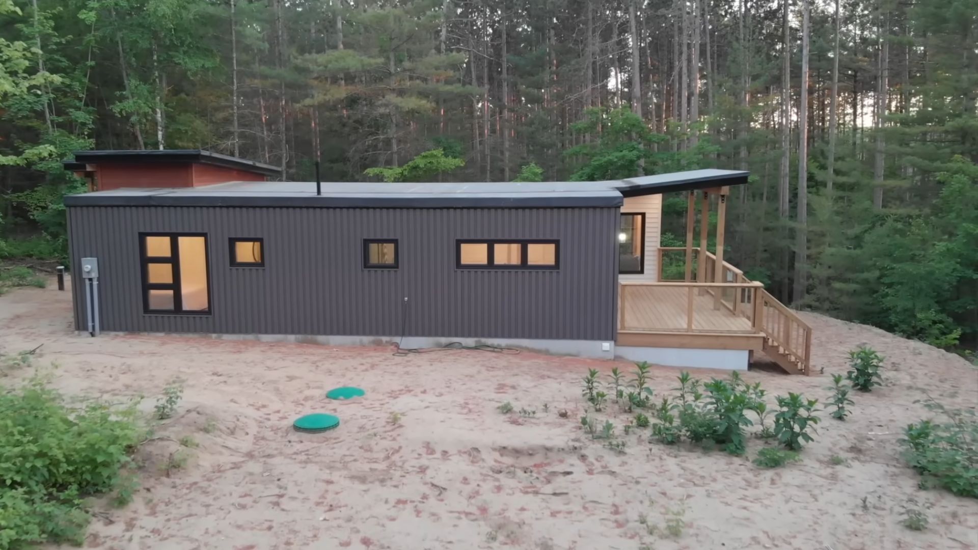 view from the side of a container home with a dominant grey corrugated wall