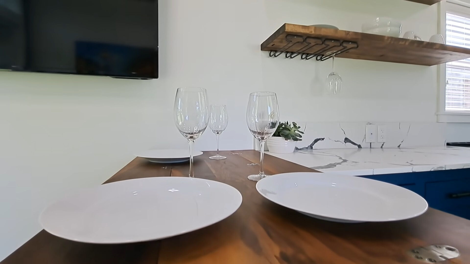 small brown dining table with plates and glasses