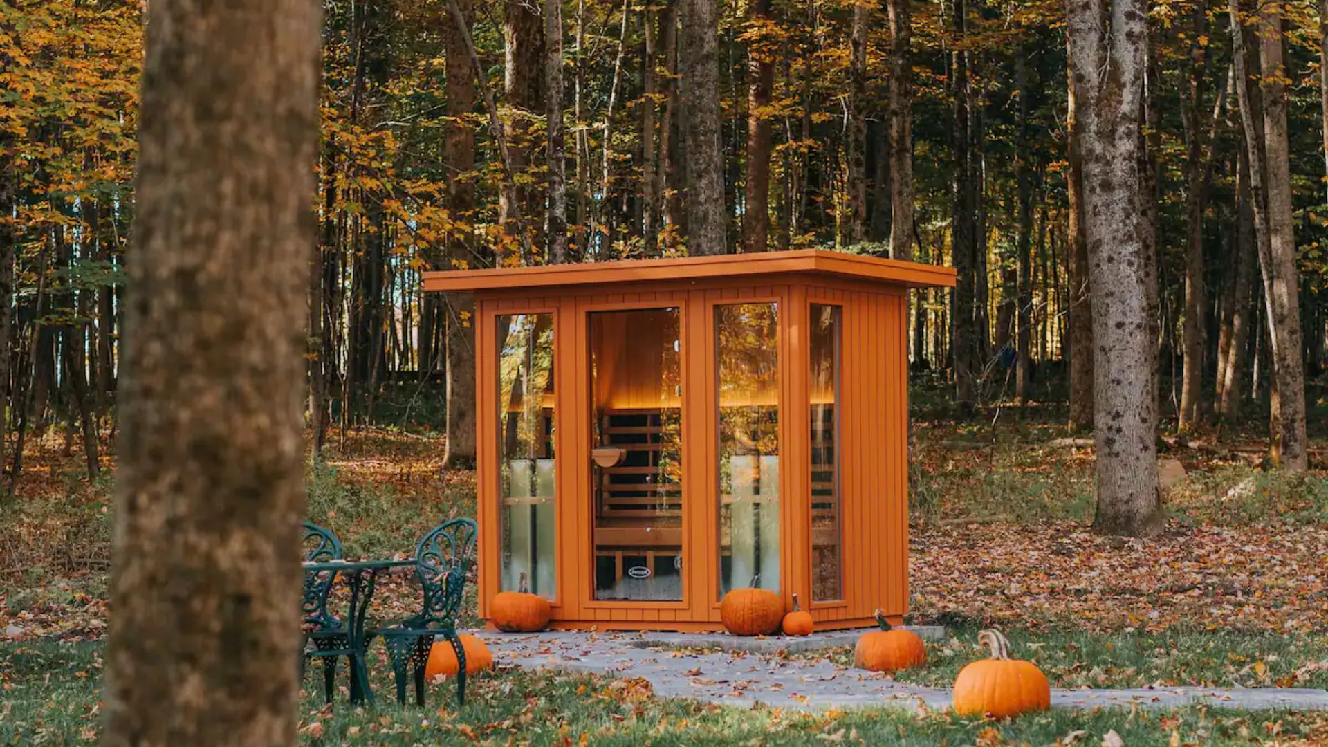 small orange sauna in the woods and pumpkin decoration