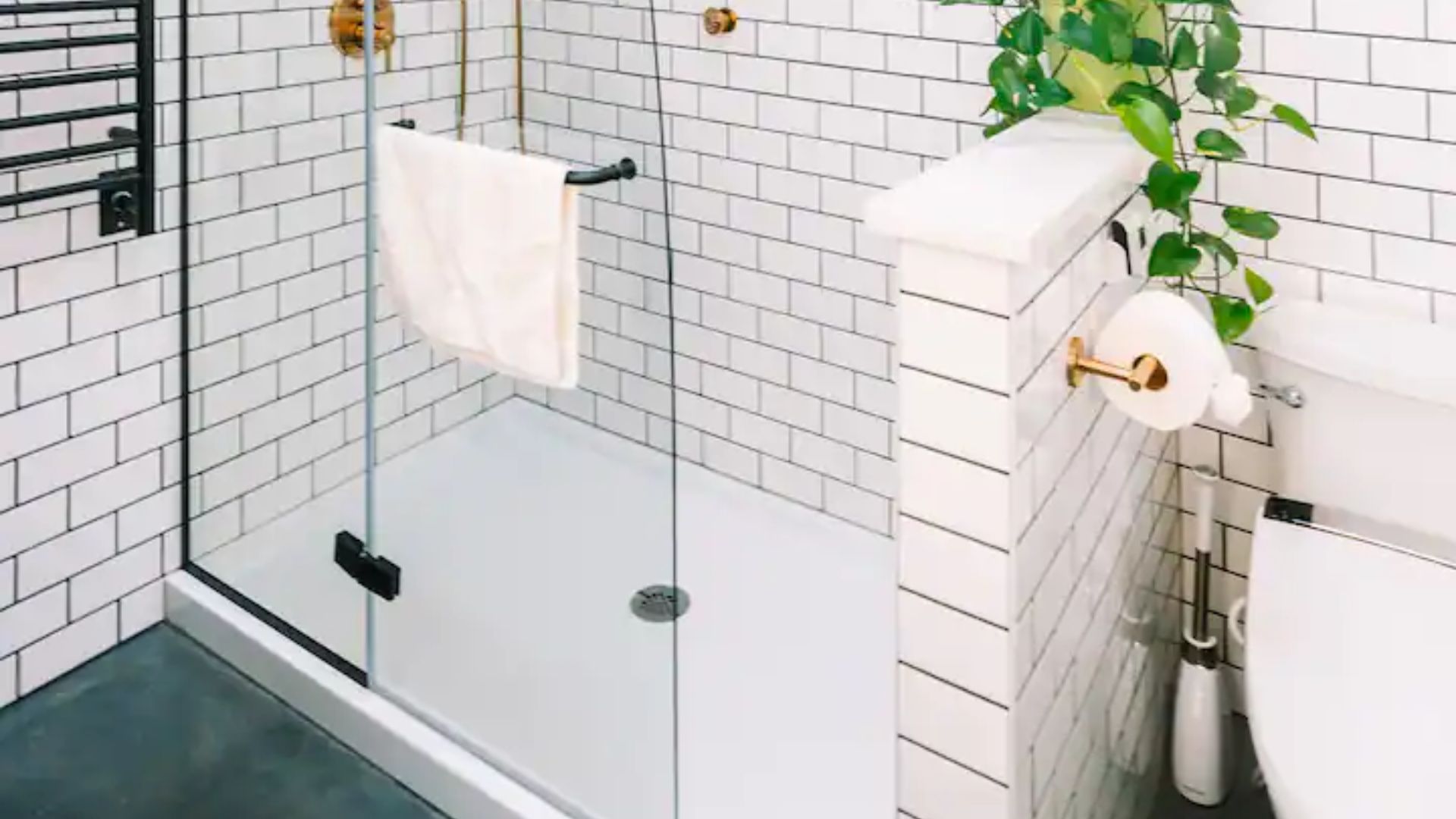 white subway tiles, glass shower with a half wall and a toilet adjacent