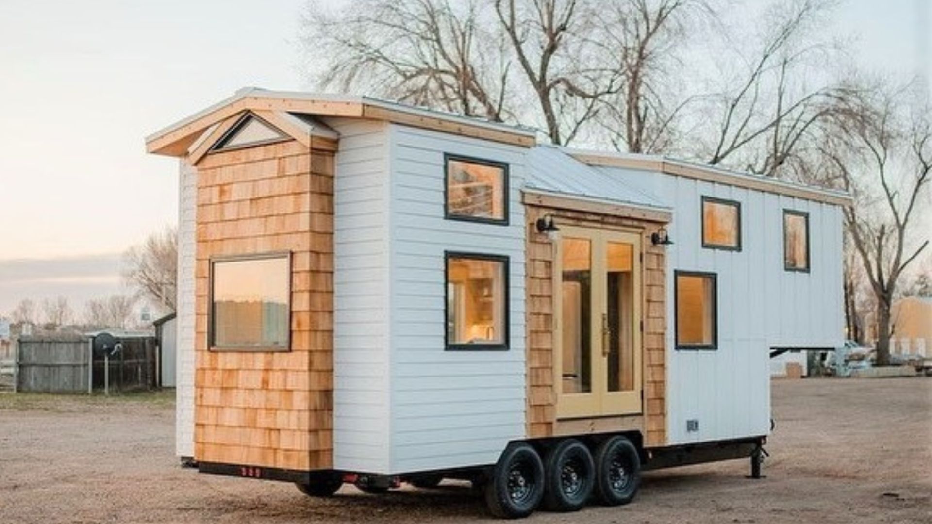 exterior of the thow house in light brown and white wood planks and lots of tiny windows with black trim