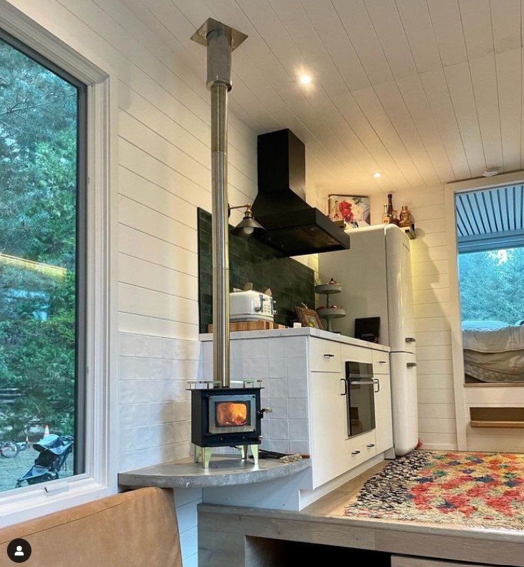 tiny fireplace in a kitchen with white cabinets