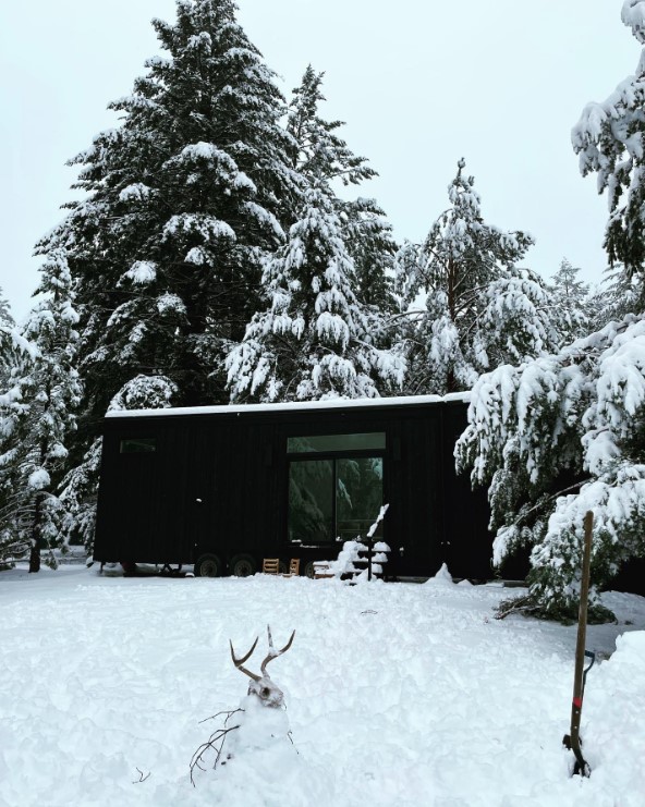 exterior of a tiny house covered in snow