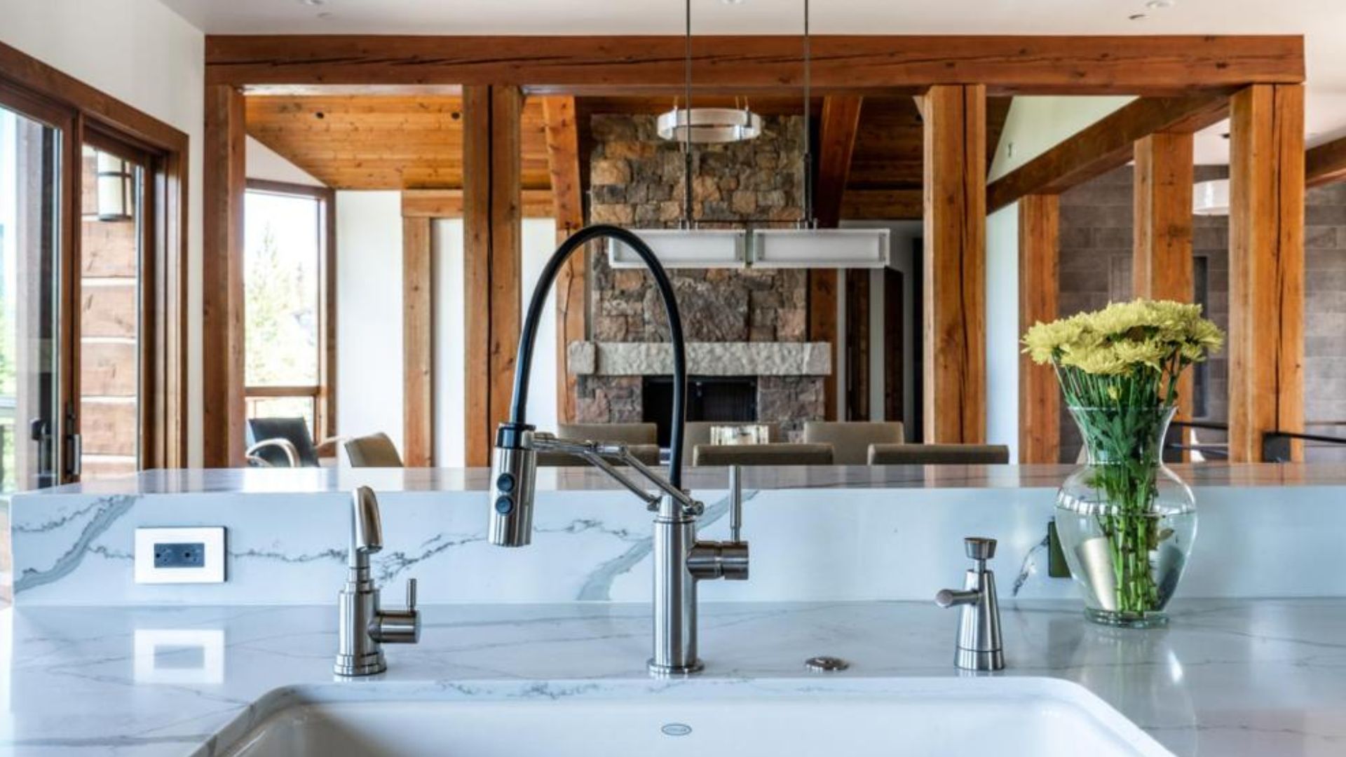 clean white marble kitchen island with a sink and lovely flowers on the right