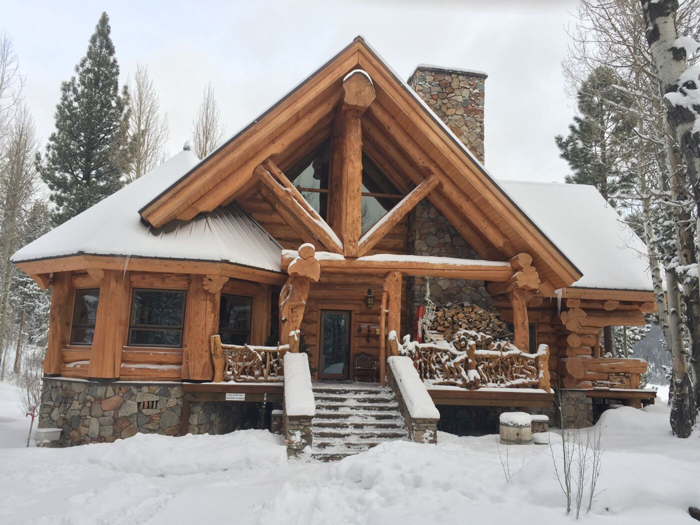 the exterior of a brown, wooden cabin covered in snow