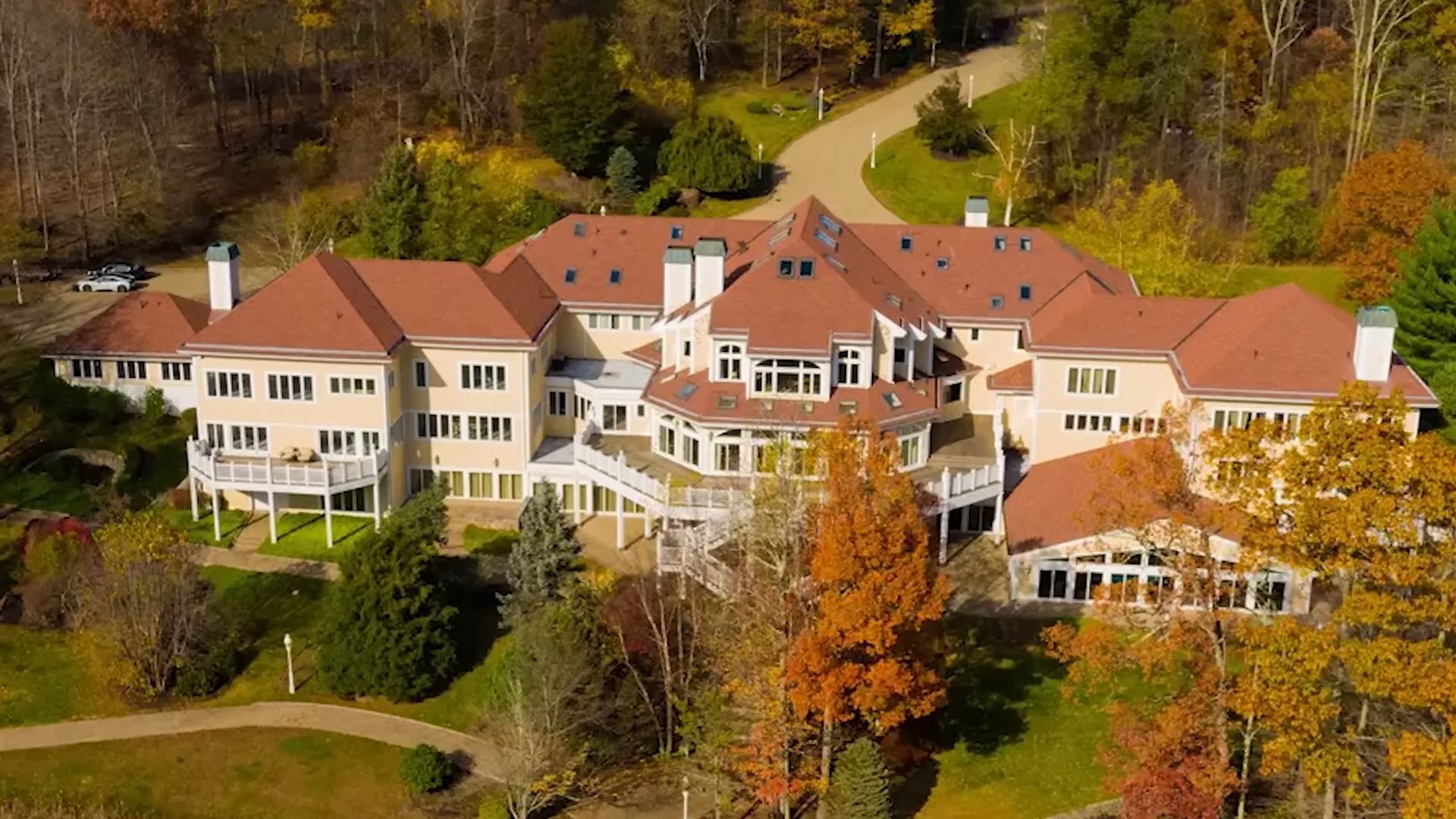 50 cent mansion in a traditional style surrounded by woods and greenery