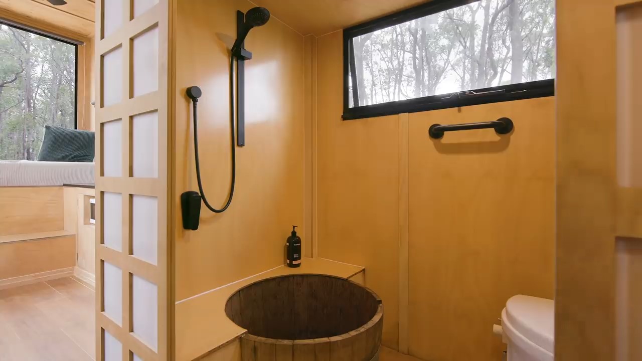 Timber bathroom with a wine barrel as a shower and black details