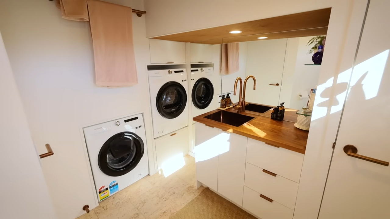 Bathroom with mirrored walls and a built-in laundry room