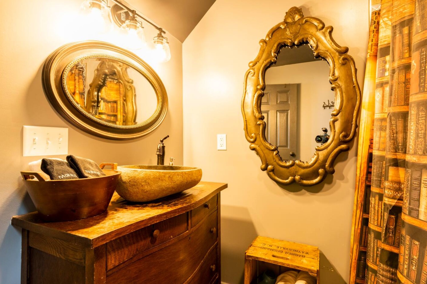 Bathroom with wooden vanity, stone sink and mirrors