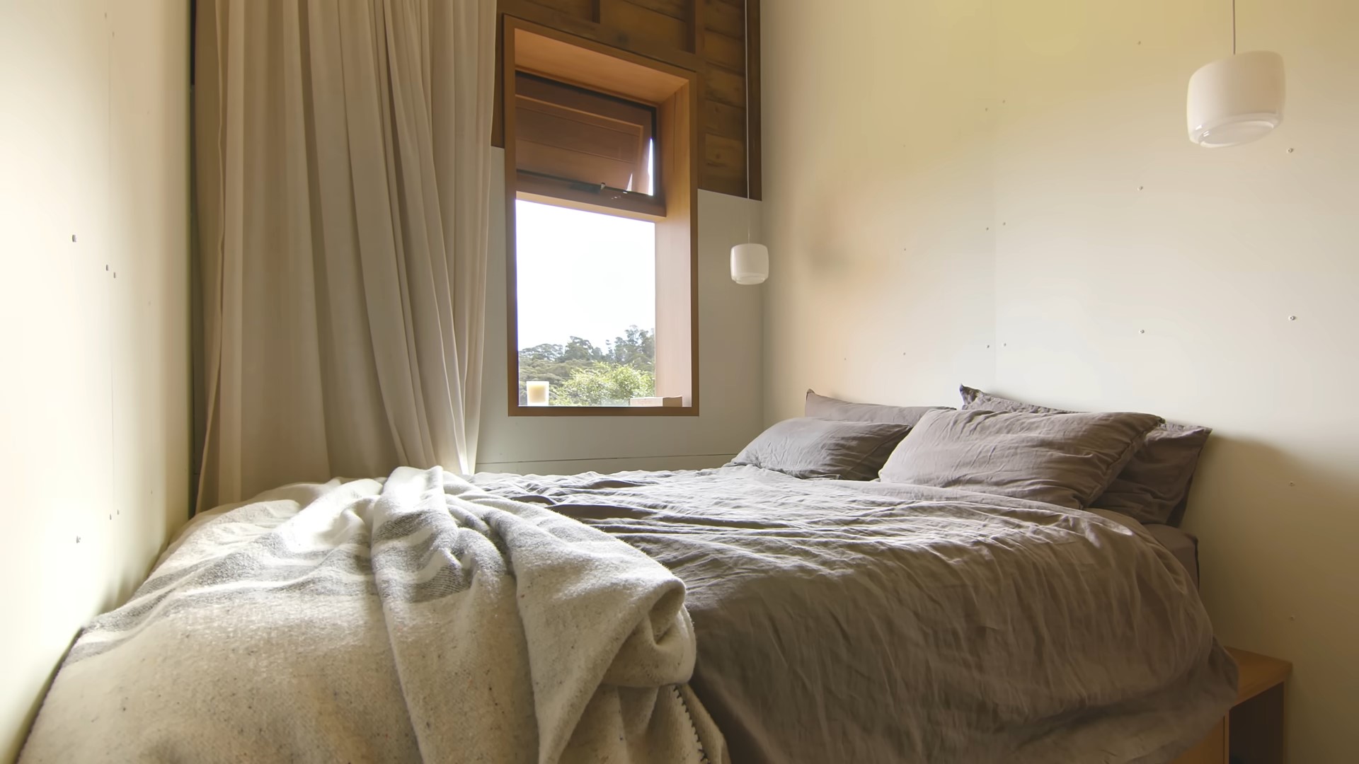 Bedroom in the corner of the room with a small wooden window