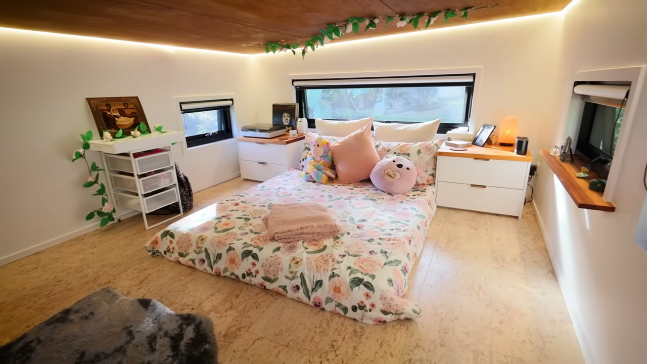 Bedroom with lowered wooden ceiling, small windows and huge bed