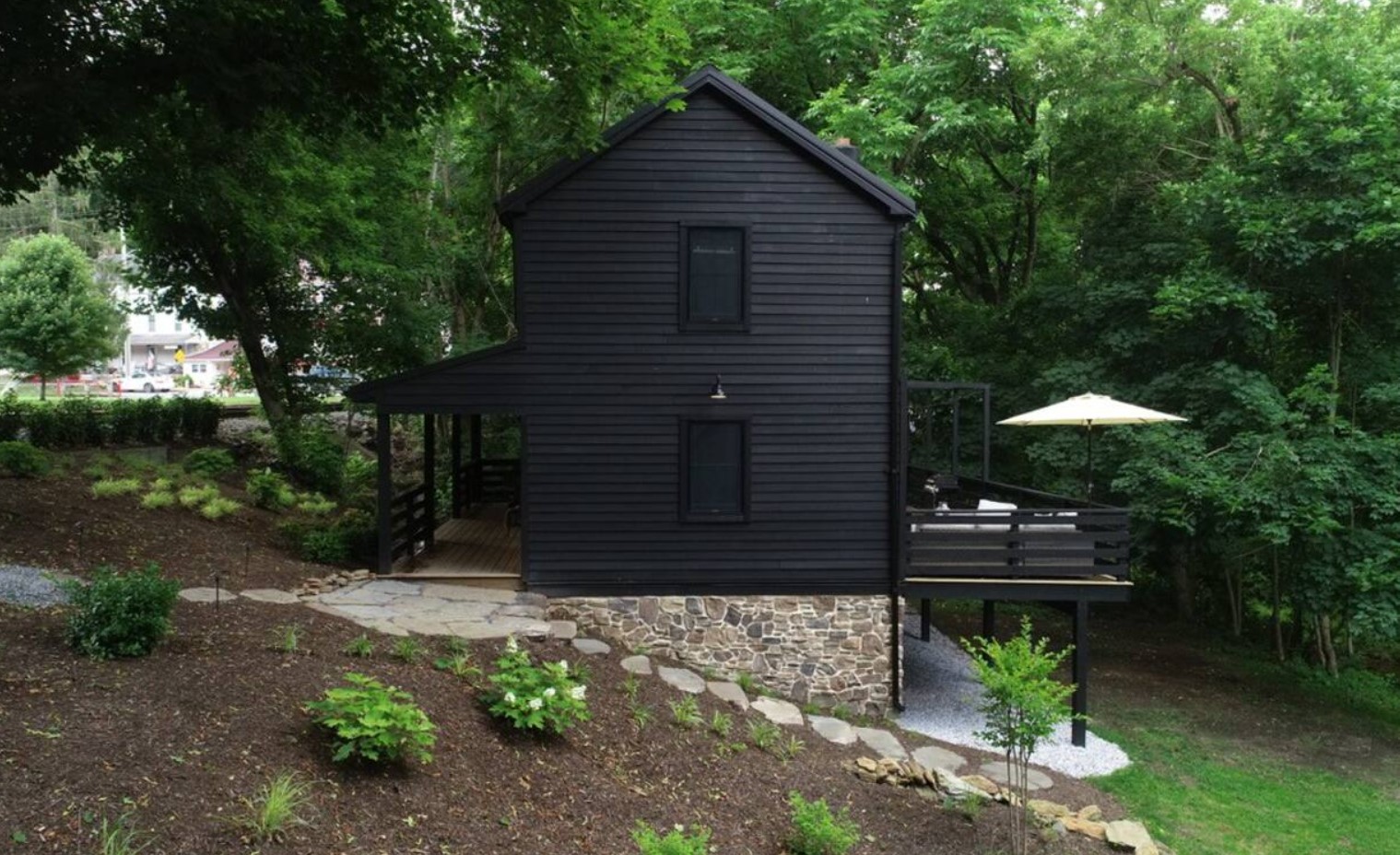 Black cabin in the forest with a deck